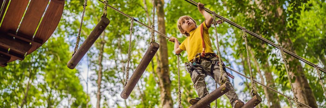 Little boy in a rope park. Active physical recreation of the child in the fresh air in the park. Training for children. BANNER, LONG FORMAT