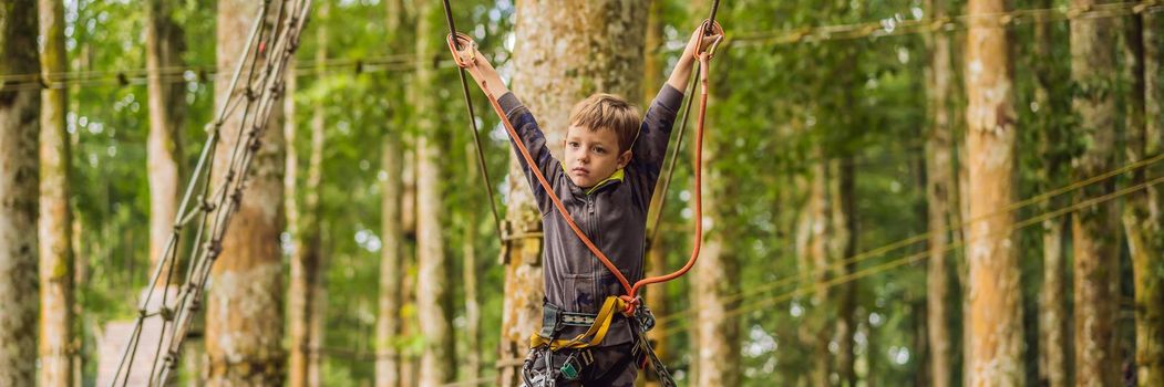 Little boy in a rope park. Active physical recreation of the child in the fresh air in the park. Training for children. BANNER, LONG FORMAT