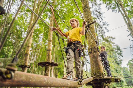 Little boy in a rope park. Active physical recreation of the child in the fresh air in the park. Training for children.