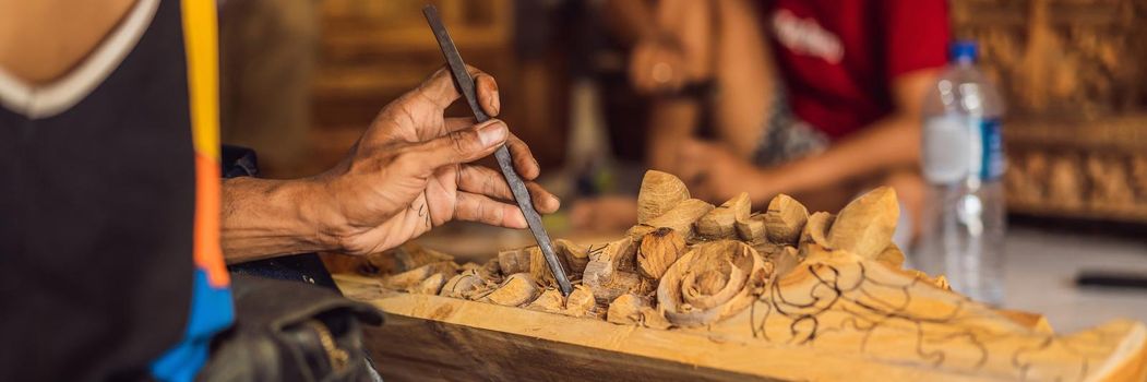 Master wood-carver made using a special knife wooden national dish - a ladle with a patterned handle. A fragment of a close-up of his hands. BANNER, LONG FORMAT