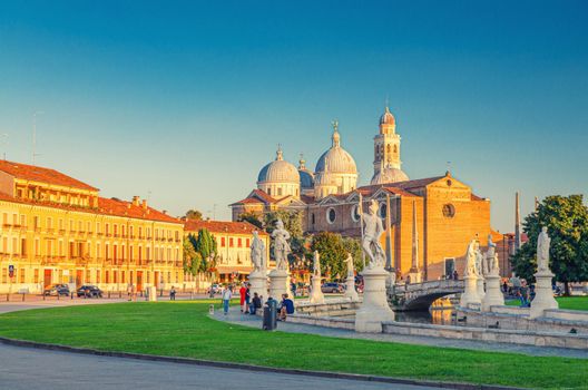 Prato della Valle square in historical city centre of Padua Padova , elliptical square with green island at the center, small canal with statues, Abbey of Santa Giustina church, Veneto Region, Italy