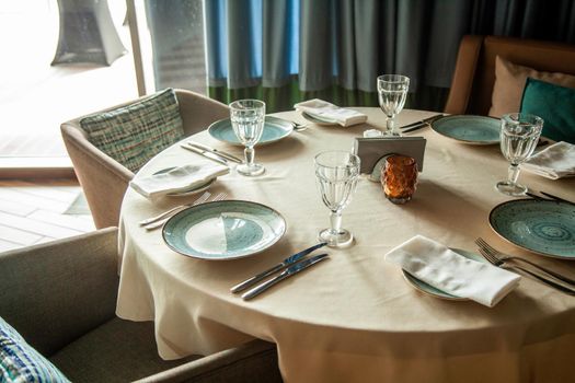 A crocked table in a restaurant, plates with glasses cutlery