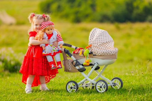 a girl rolls her doll on a toy stroller