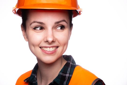 woman in construction safety helmet and orange vest, close-up portrait. High quality photo