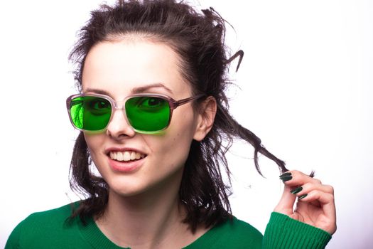 curly brunette woman in green glasses and green cardigan. High quality photo