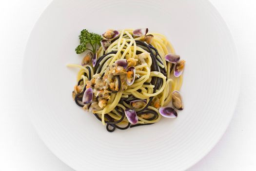 Spaghetti pasta with wedge clams arselle top view on a white dish