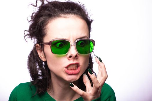 curly brunette woman in green glasses and green cardigan. High quality photo
