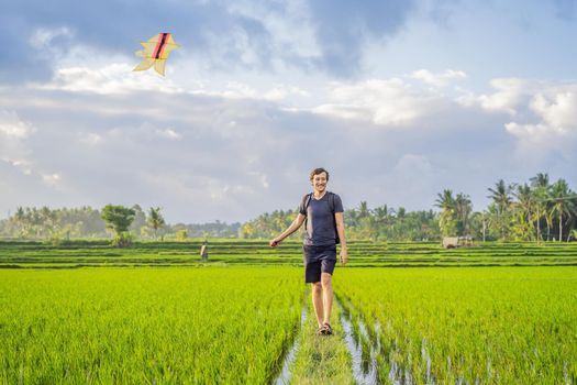 Man launch a kite in a rice field in Ubud, Bali Island, Indonesia.