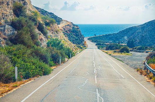 Asphalt seaside road among hills leading to Mediterranean sea, Cyprus