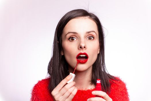 beautiful young woman paints lips with lipstick. High quality photo