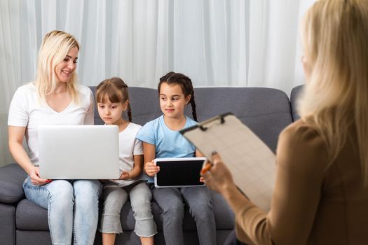 Hand of a professional family psychotherapist writing notes in front of a family with a child during a consultation.