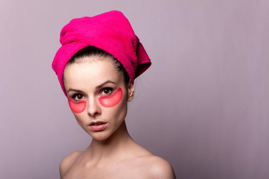young woman after a shower in a pink towel and patches. High quality photo