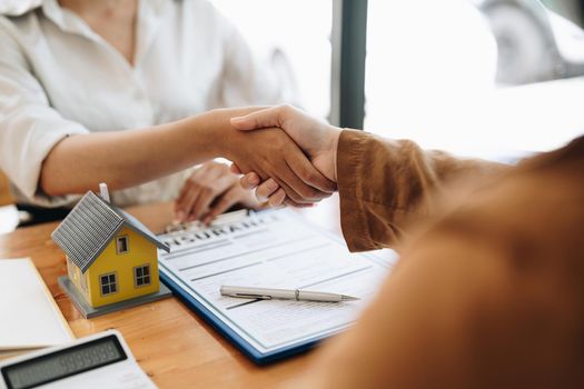 Successful agreement , estate,home buying contract concept, buyer shaking hand with bank empoyees after finishing signing contract in office.