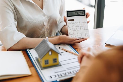Real estate agent or bank officer describes the loan interest to the customer with home purchase contracts or on office loans and interest rates