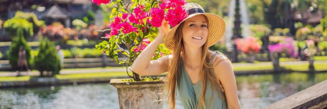 Young woman tourist in Taman Tirtagangga, Water palace, Water park, Bali Indonesia. BANNER, LONG FORMAT