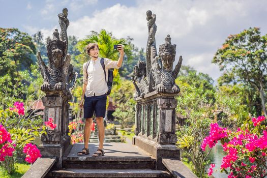 Young man tourist in Taman Tirtagangga, Water palace, Water park, Bali Indonesia.