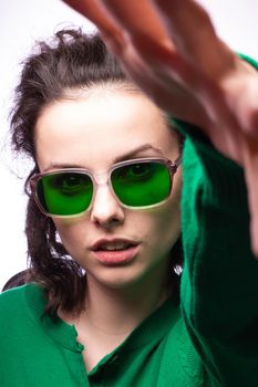 curly brunette woman in green glasses and green cardigan. High quality photo