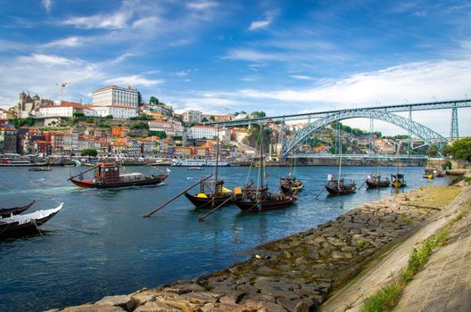 Portugal, city landscape Porto, wooden boats with wine port barrels on Douro river, panoramic view of the old town Porto, The Eiffel Bridge view, Ponte Dom Luis, Porto in summer, colored houses