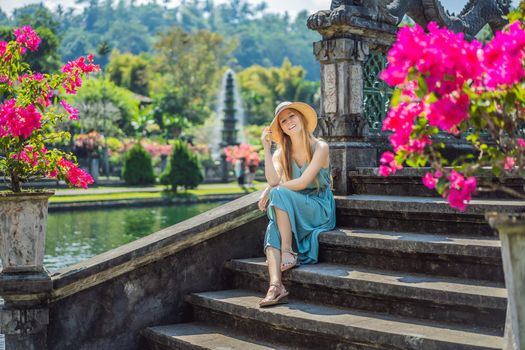 Young woman tourist in Taman Tirtagangga, Water palace, Water park, Bali Indonesia.