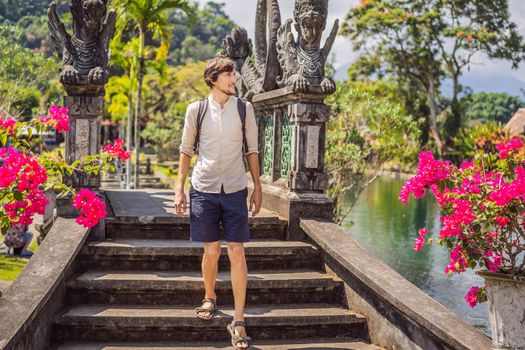 Young man tourist in Taman Tirtagangga, Water palace, Water park, Bali Indonesia.