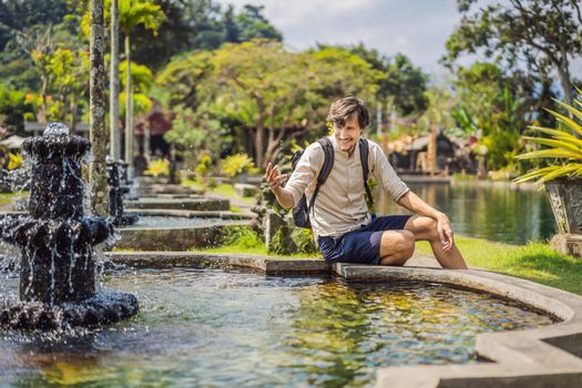 Young man tourist in Taman Tirtagangga, Water palace, Water park, Bali Indonesia.