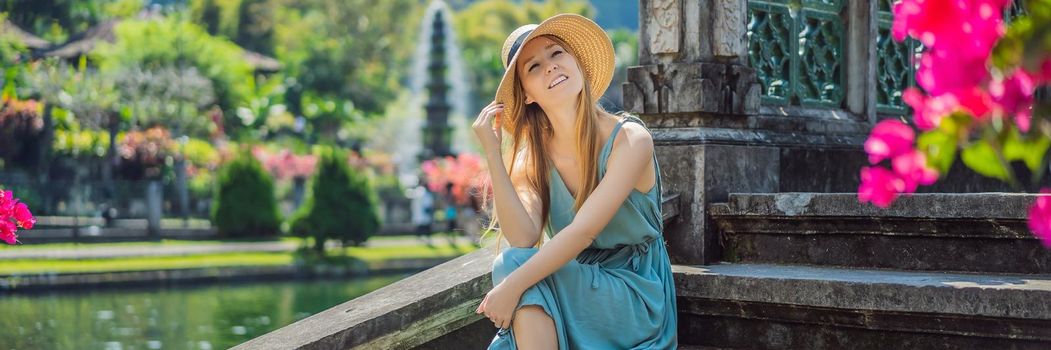 Young woman tourist in Taman Tirtagangga, Water palace, Water park, Bali Indonesia. BANNER, LONG FORMAT