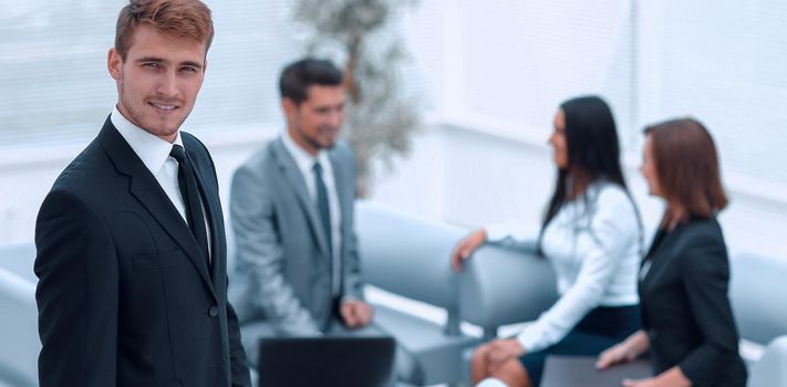 portrait of confident businessman on background of office. photo with copy space