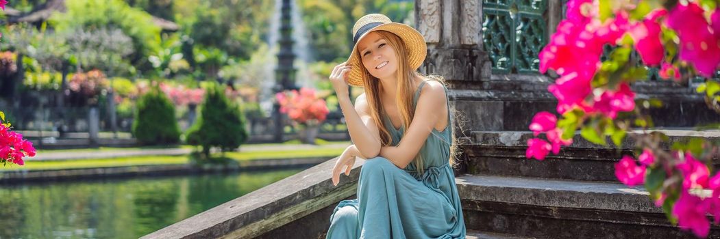 Young woman tourist in Taman Tirtagangga, Water palace, Water park, Bali Indonesia. BANNER, LONG FORMAT