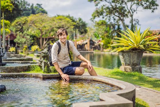 Young man tourist in Taman Tirtagangga, Water palace, Water park, Bali Indonesia.
