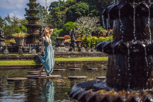 Young woman tourist in Taman Tirtagangga, Water palace, Water park, Bali Indonesia.