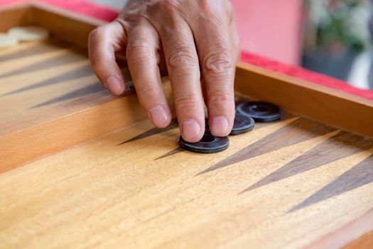 a man moves a pool in a backgammon game