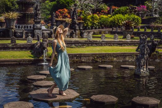 Young woman tourist in Taman Tirtagangga, Water palace, Water park, Bali Indonesia.