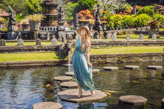 Young woman tourist in Taman Tirtagangga, Water palace, Water park, Bali Indonesia.
