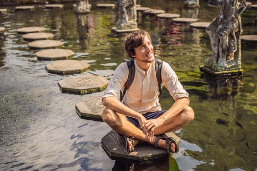 Young man tourist in Taman Tirtagangga, Water palace, Water park, Bali Indonesia.