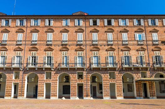 Prefecture Palazzo del Governo Palace brick building with arches, windows and shutters on Castle Square Piazza Castello in historical centre of Turin Torino city with clear blue sky, Piedmont, Italy