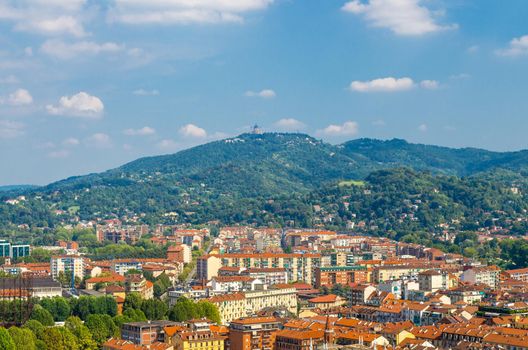 Aerial view from Mole Antonelliana tower platform of Turin Torino Borgo Po city district quarter and Basilica di Superga Catholic church on hill, blue sky white clouds background, Piedmont, Italy