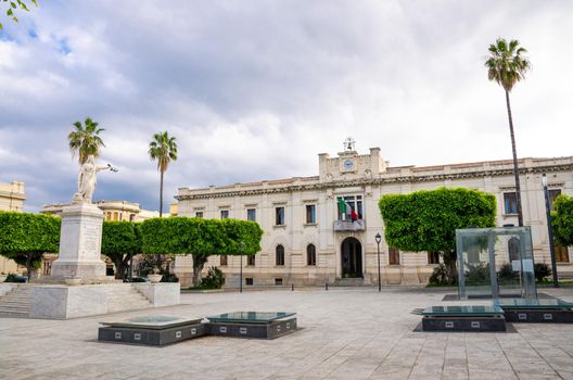 Archeologic Area Ipogea Piazza Italia square, building of Palazzo San Giorgio and green palm trees in historical centre of the city Reggio di Calabria, Southern Italy