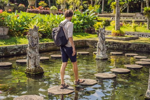 Young man tourist in Taman Tirtagangga, Water palace, Water park, Bali Indonesia.