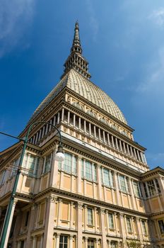 Mole Antonelliana tower National Cinema Museum building with spire steeple is major landmark and symbol of Turin Torino city, view from below, blue sky background, Piedmont, Italy