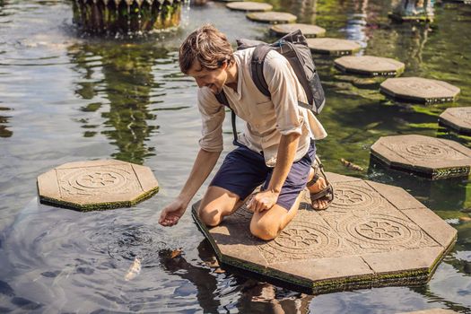 Young man tourist in Taman Tirtagangga, Water palace, Water park, Bali Indonesia.