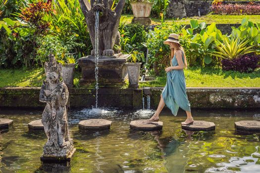 Young woman tourist in Taman Tirtagangga, Water palace, Water park, Bali Indonesia.