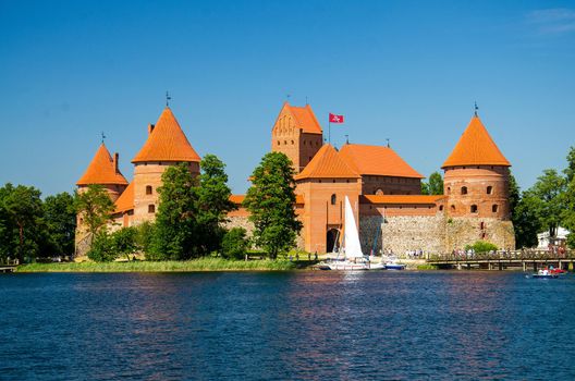 Medieval gothic Trakai Island Castle with stone walls and towers with red tiled roofs in Lake Galve, Lithuania