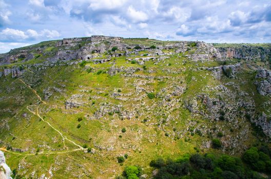 View of ravine canyon with rocks and houses in caves di Murgia Timone near old ancient town Matera (Sassi), UNESCO World Heritage, Basilicata, Southern Italy