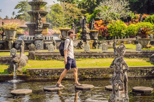 Young man tourist in Taman Tirtagangga, Water palace, Water park, Bali Indonesia.