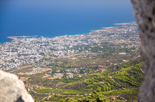 View of Kyrenia Girne town and Mediterranean sea from ruins of medieval Saint Hilarion Castle in front of blue sky with white clouds, Northern Cyprus