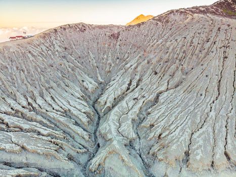 Aerial shot of the Ijen volcano or Kawah Ijen on the Indonesian language. Famous volcano containing the biggest in the world acid lake and sulfur mining spot at the place where volcanic gasses come from the volcano.