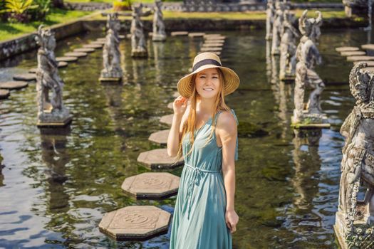 Young woman tourist in Taman Tirtagangga, Water palace, Water park, Bali Indonesia.