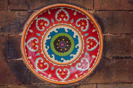 Balinese decoration, painted plate on a stone wall.
