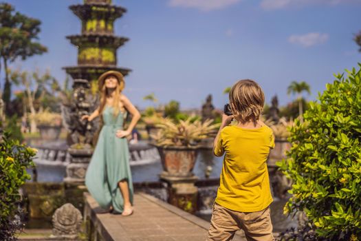 Mom and son tourists in Taman Tirtagangga, Water palace, Water park, Bali Indonesia. Honeymoon in Bali. Traveling with children concept. Kids friendly place.