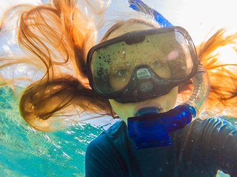 Happy woman in snorkeling mask dive underwater with tropical fishes in coral reef sea pool. Travel lifestyle, water sport outdoor adventure, swimming lessons on summer beach holiday.